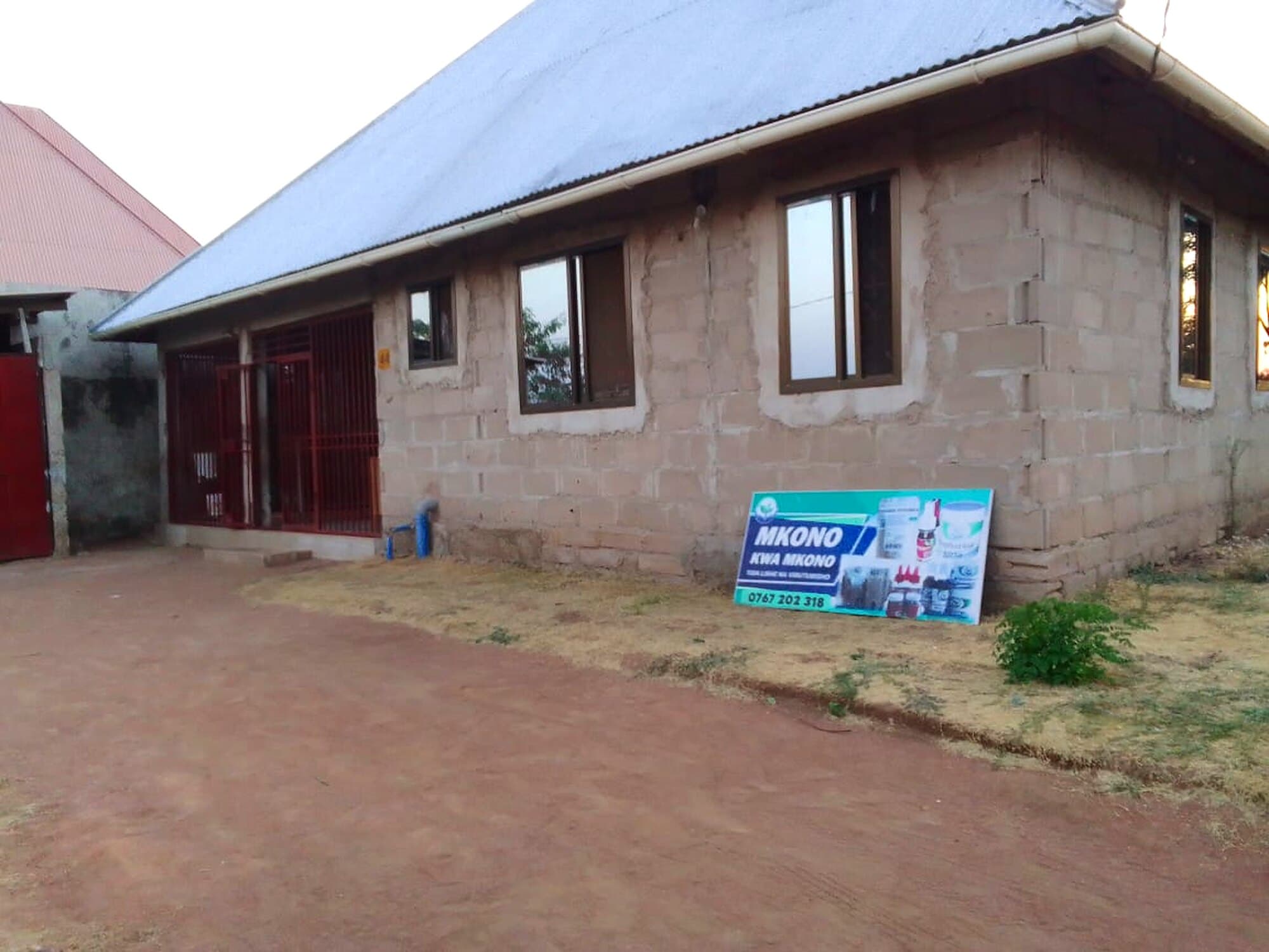 Originalfoto aus Mwanza: das Gebäude von Hand in Hand mit unverputzten Steinwänden und fertigem Dach